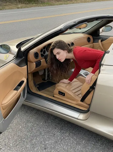 Девушка наклоняется в открытую дверь бежевого кабриолета Ferrari, руки на кожаном сиденье